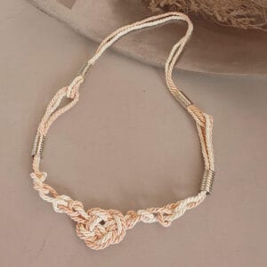 colar de macrame em corda de viscose e algodão, na combinação de cores rosa e cru com detalhes em metal prateado