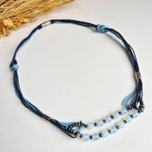 colar artesanal feito com fios de algodão nas cores azul marinho e turquesa. detalhes com pedra da lua intercalada com hematita