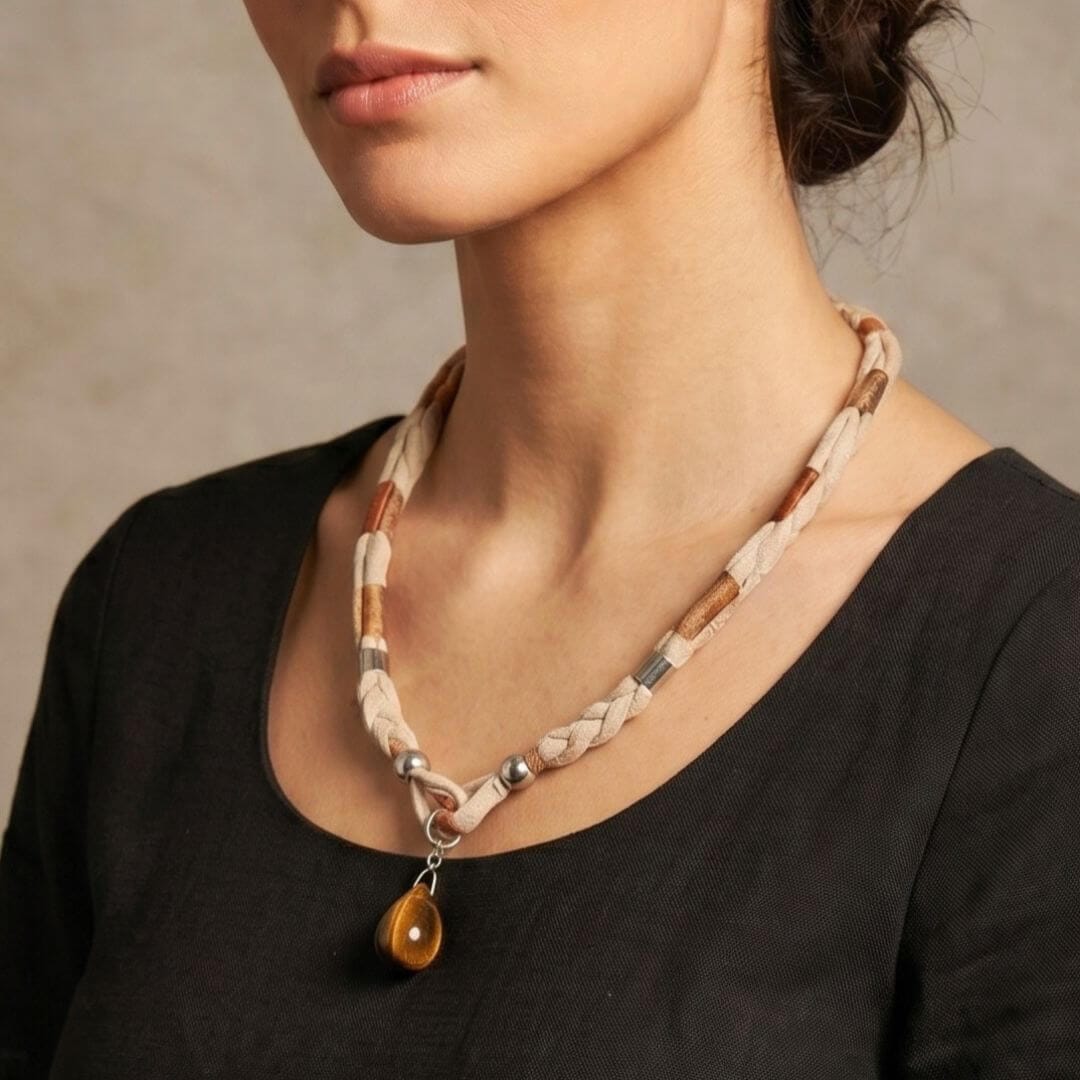 modelo feminino usando colar artesanal em fio de malha cor bege com pendente olho de tigre